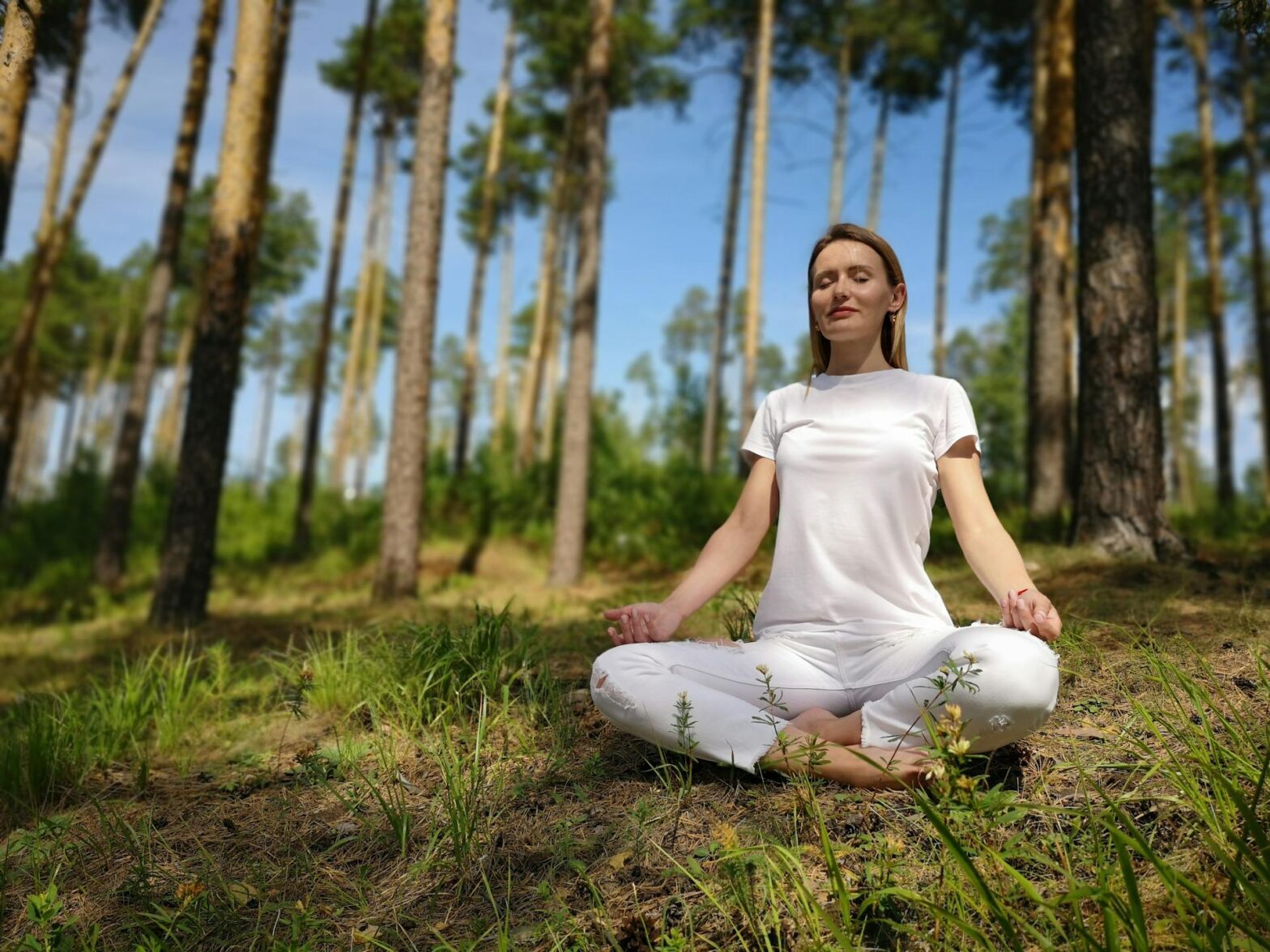 Person meditating outdoors, practicing self-care in nature